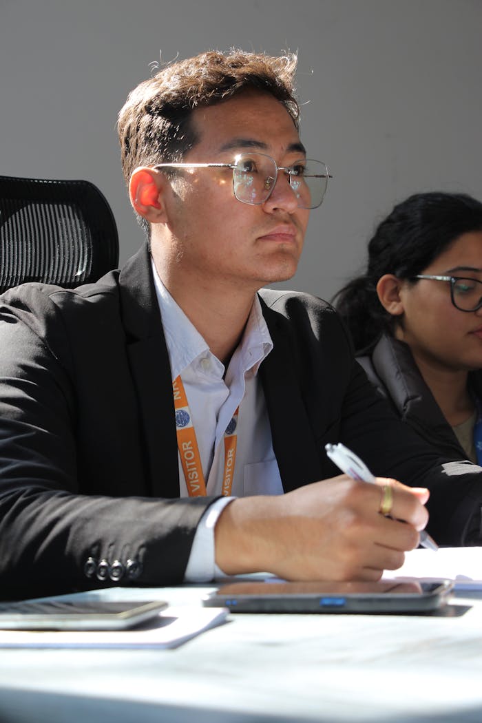 University students attentively participating in a seminar, taking notes and listening closely.